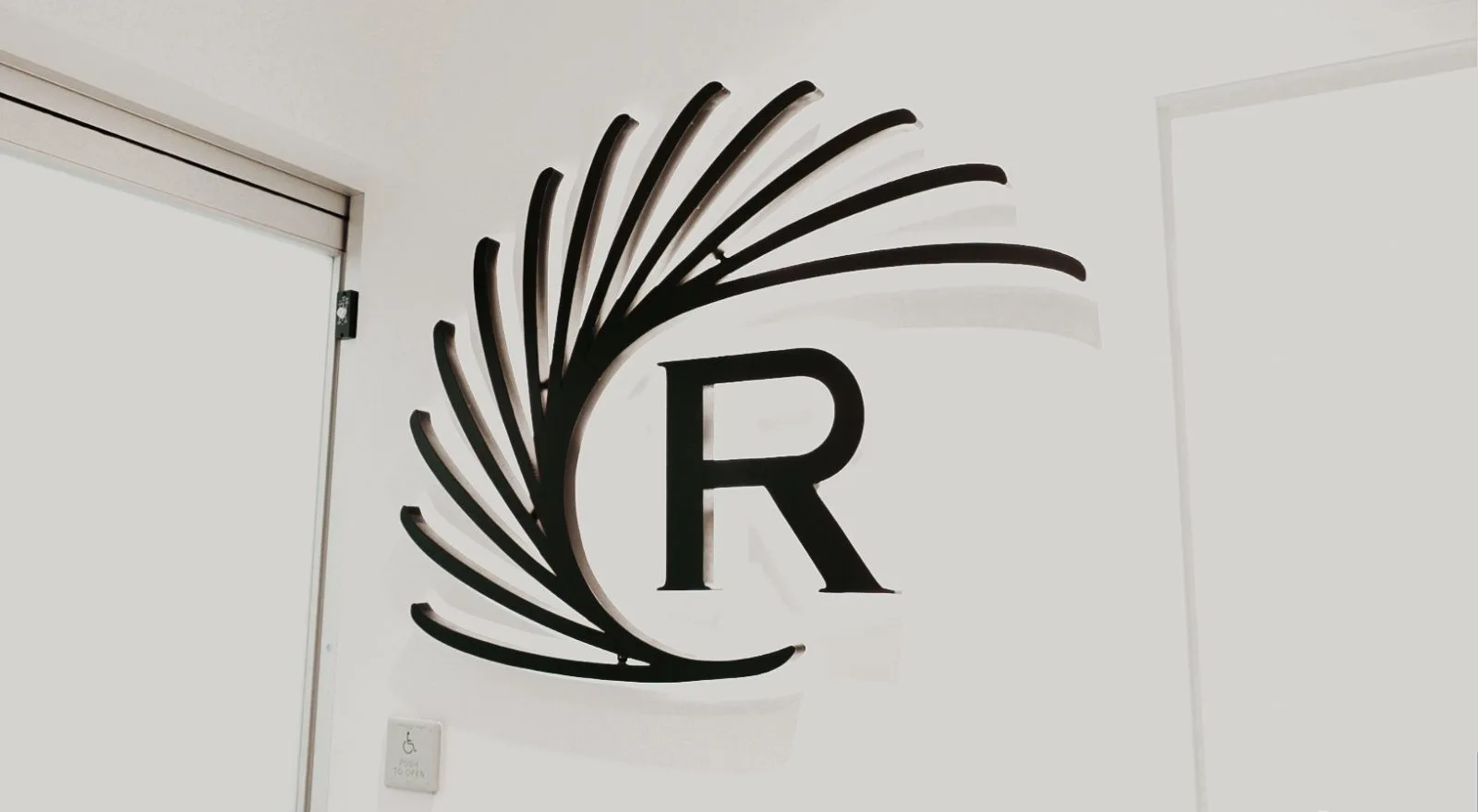 Regency Specialties logo with stylized leaf design on clinic wall